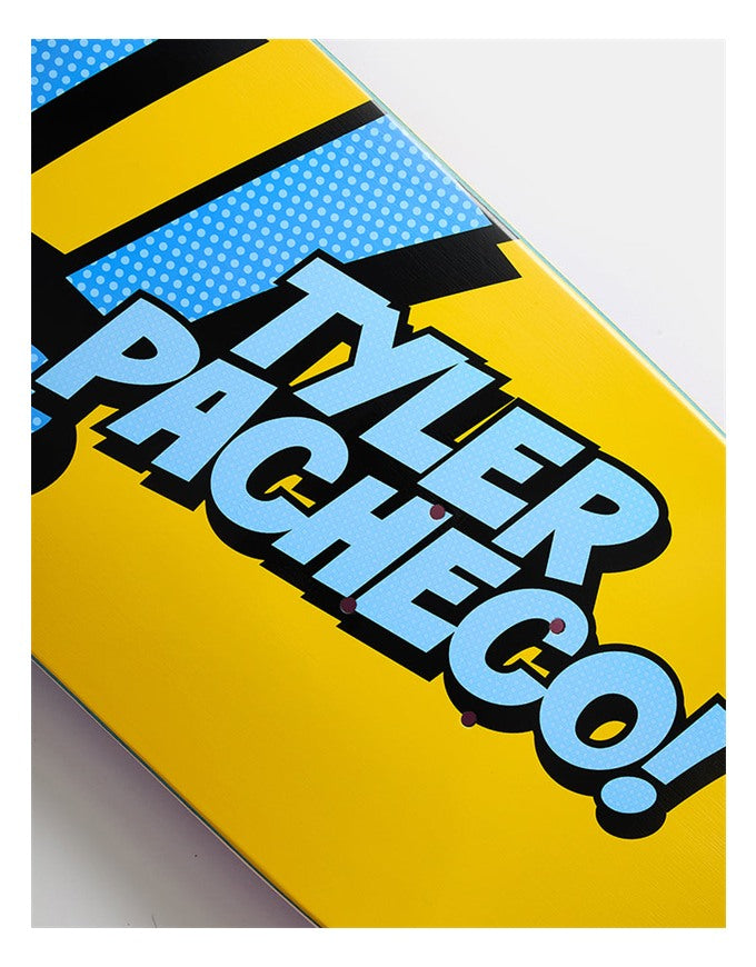 Close-up of a skateboard deck featuring a bold comic-style graphic with the text 'TYLER PACHECO!' in light blue with black outlines, set against a bright yellow background with a blue dotted pattern.