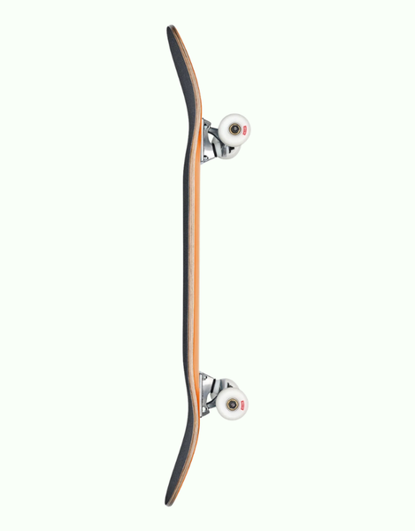 A skateboard shown vertically from the side against a solid off-white background, featuring a light brown wood-grain deck, black grip tape, silver trucks, and white wheels.