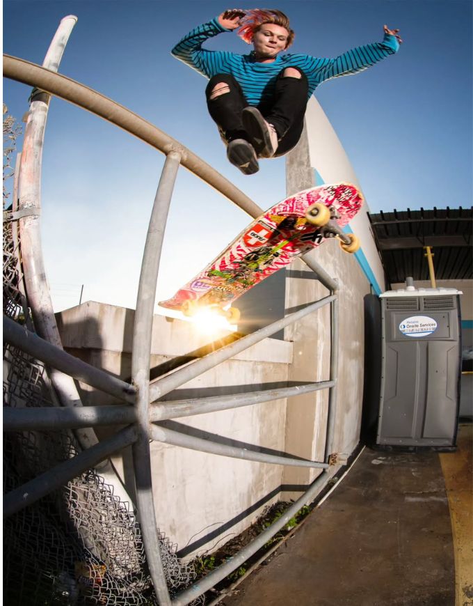 Person skateboarding off a metal railing with a colorful skateboard